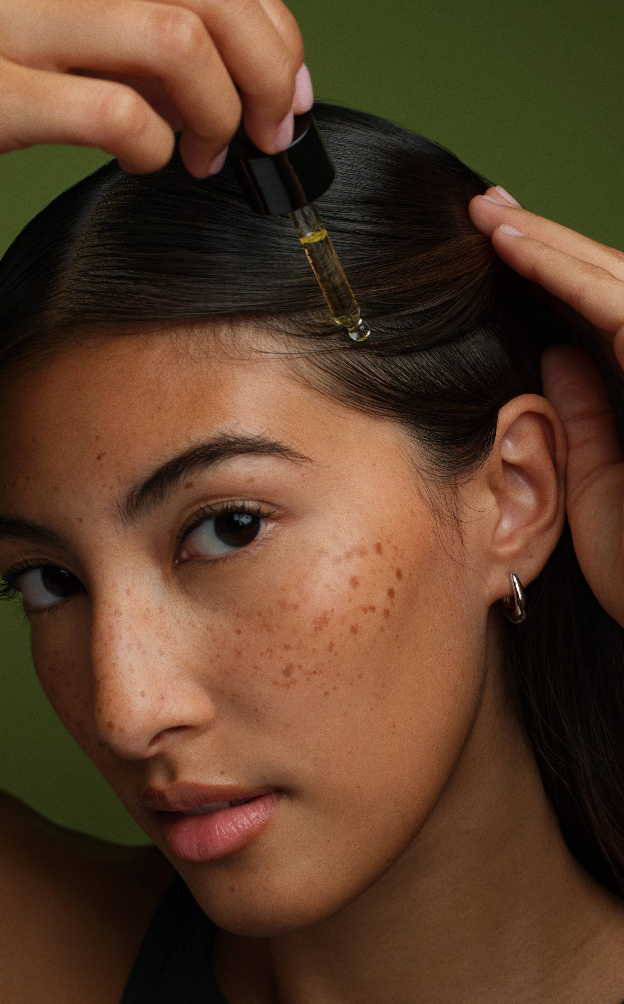 Close-up of a model using Prose Custom Scalp Serum on their scalp.