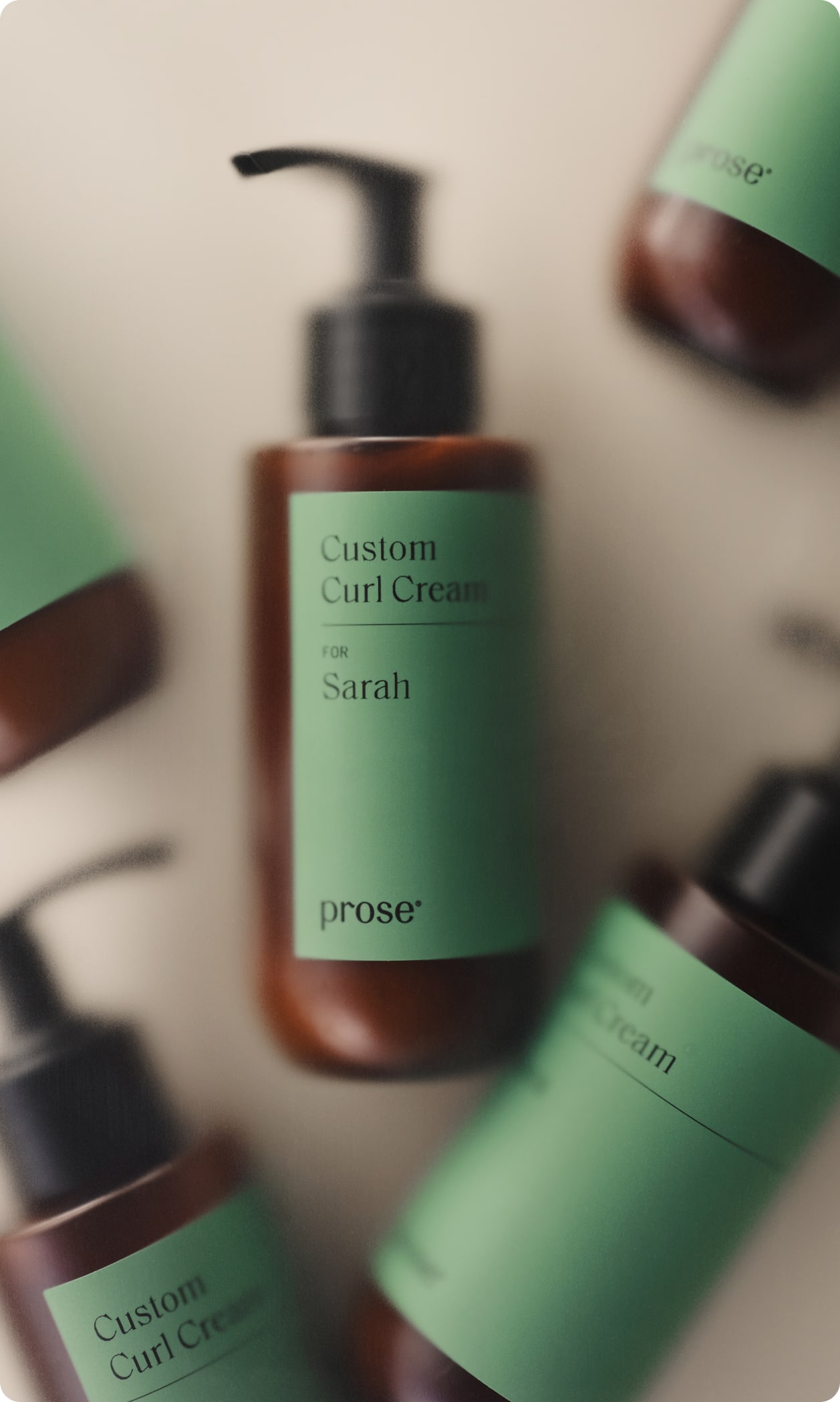 Multiple Prose Custom Curl Cream bottles with one in focus labeled “for Sarah.